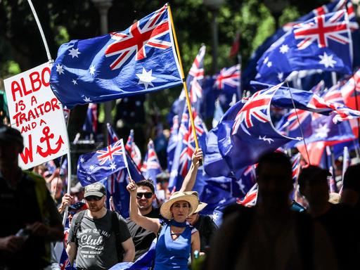 Demonstranten halten die australische Flagge hoch.