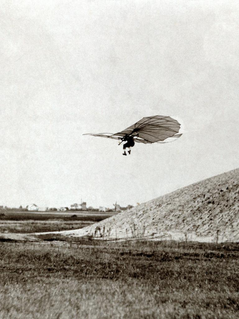 Flugpionier Otto Lilienthal fliegt mit einem Gleitflieger im 19. Jahrhundert von einem Hügel herunter.