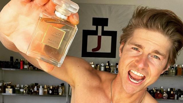 Ein Selfie von Jeremy Fragrance von seinem Social Media Account, er hält eine Parfümflasche in die Kamera und hat einen trainierten Oberkörper.
