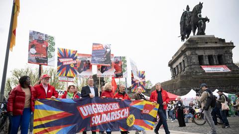 Teilnehmer tragen auf der zentralen 1.-Mai-Kundgebung des Deutscher Gewerkschaftsbunds für Rheinland-Pfalz einen Banner auf dem "Ungebrochen Solidarisch" vor dem Kaiser-Wilhelm-Denkmal entlang.