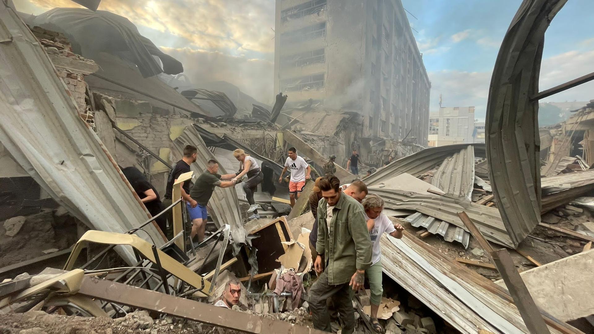 Such- und Rettungsarbeiten nach einem russischen Raketenangriff auf ein Restaurant in Kramatorsk, Ukraine, am 27. Juni 2023. Blutüberströmte Menschen suchen verzweifelt nach Überlebenden in einem Trümmerhaufen.