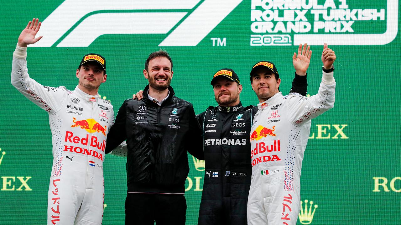 Die Formel-1-Fahrer Verstappen, Bottas und Perez stehen während einer Siegerehrung mit einem Mechaniker auf dem Podest.