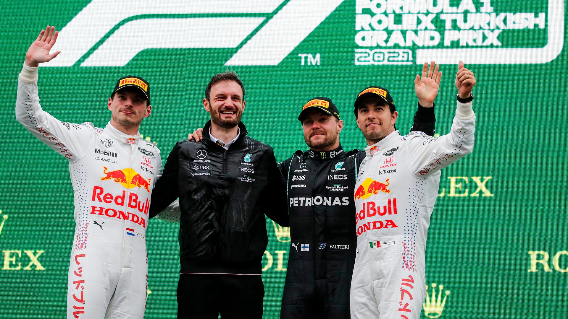 Die Formel-1-Fahrer Verstappen, Bottas und Perez stehen während einer Siegerehrung mit einem Mechaniker auf dem Podest.
