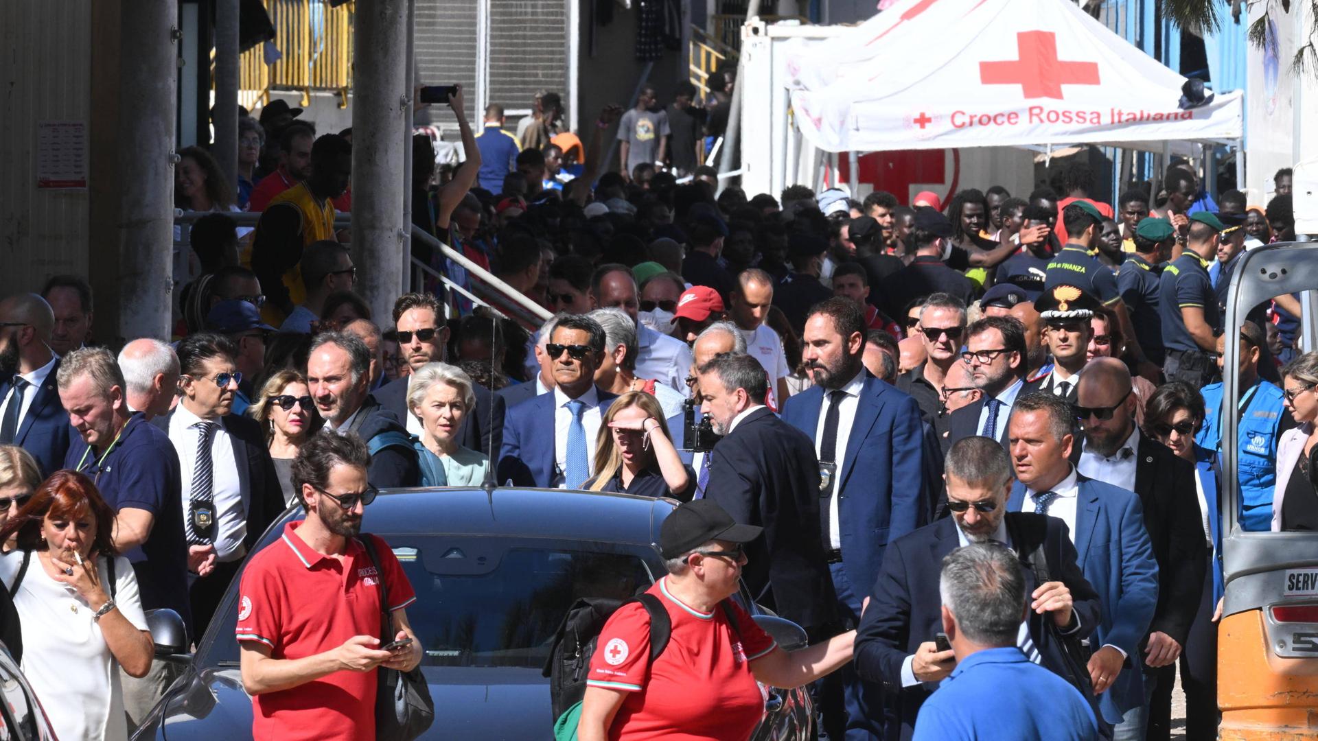 Zu sehen ist eine Szene von der italienischen Insel Lampedusa. Unter anderem EU-Kommissionspräsidentin von der Leyen und Italiens Ministerpräsidentin Meloni laufen hinter einem Auto.