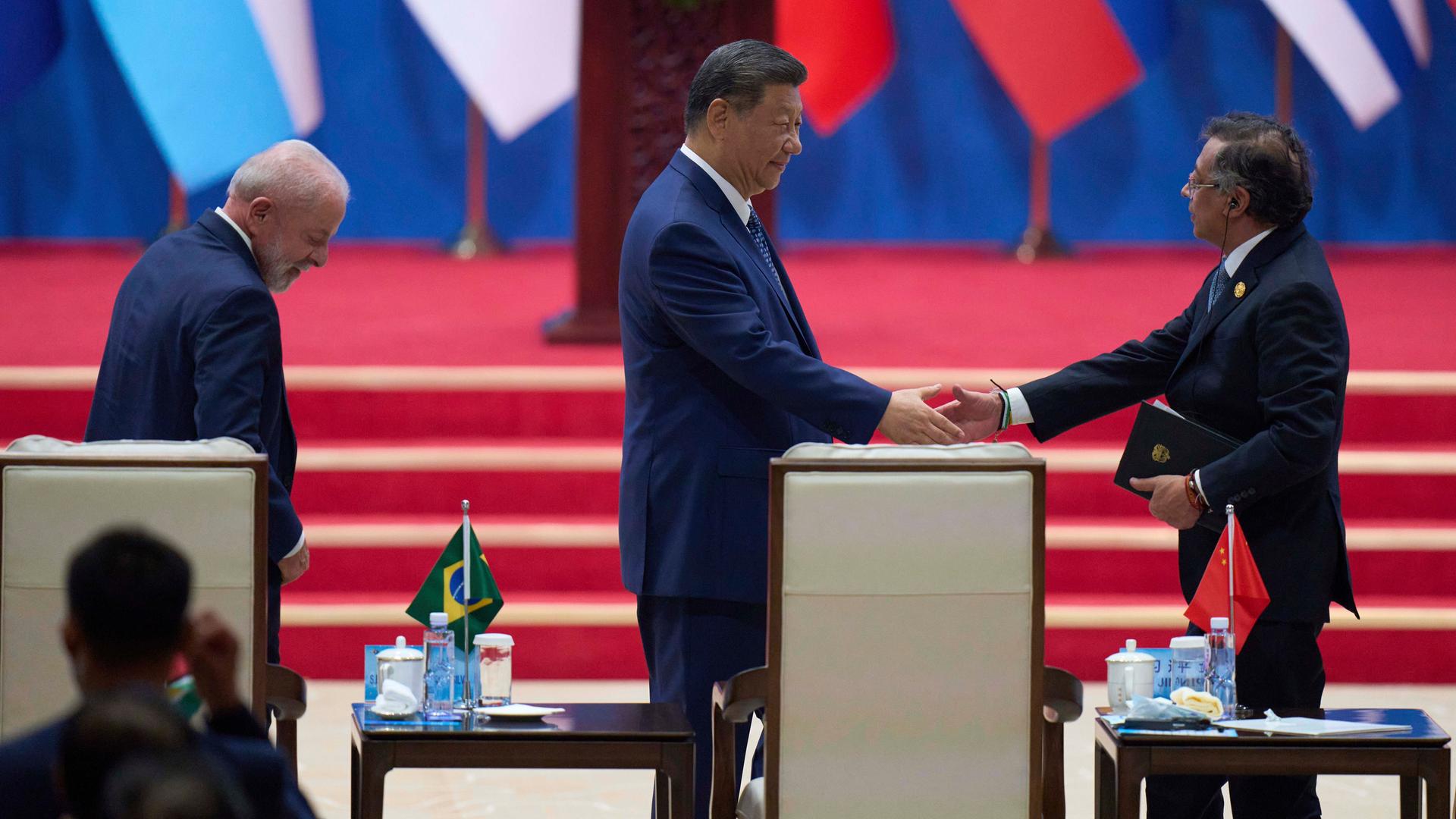 Chinas Präsident Xi Jinping, Mitte, und Kolumibiens Präsident Gustavo Petro, rechts, schütteln sich die Hände.