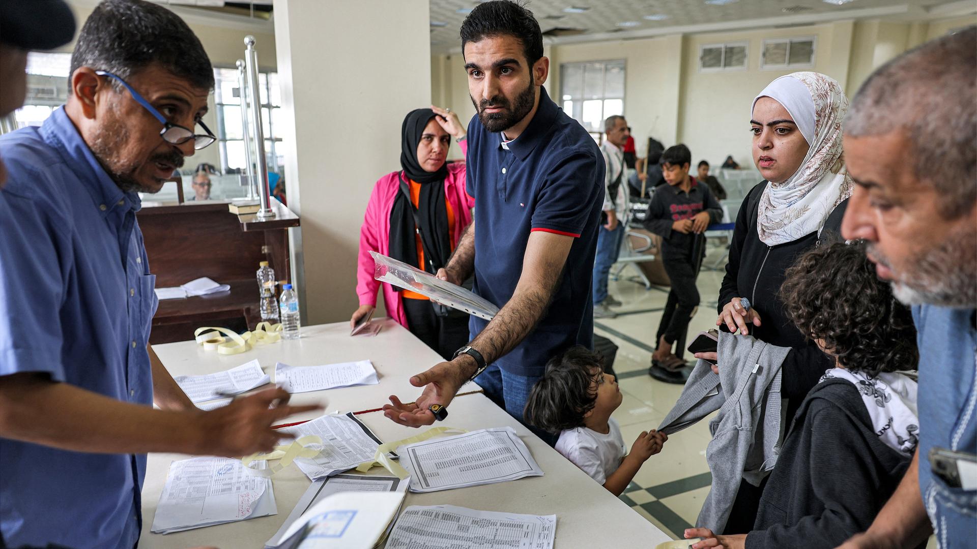 Ein Grenzbeamter kontrolliert die Pässe mehrerer Personen am Grenzübergang Rafah zwischen dem Gazastreifen und Ägypten.