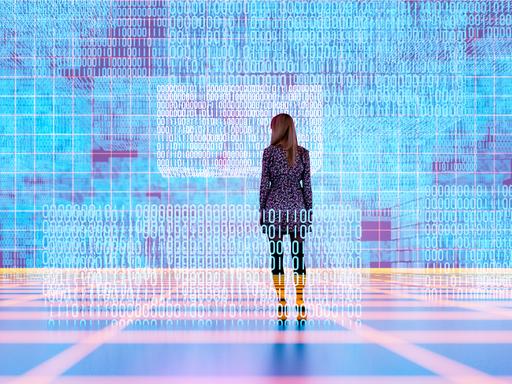 Eine weibliche Persons steht in einem digitalen Raum und schaut auf zahlreiche Coding-Reihen