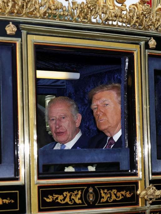 König Charles III. und US-Präsident Donald Trump sitzen während einer Parade durch Windsor Castle anlässlich des Staatsbesuchs des Präsidenten am 17. September 2025 in Windsor, England, in einer goldenen Kutsche