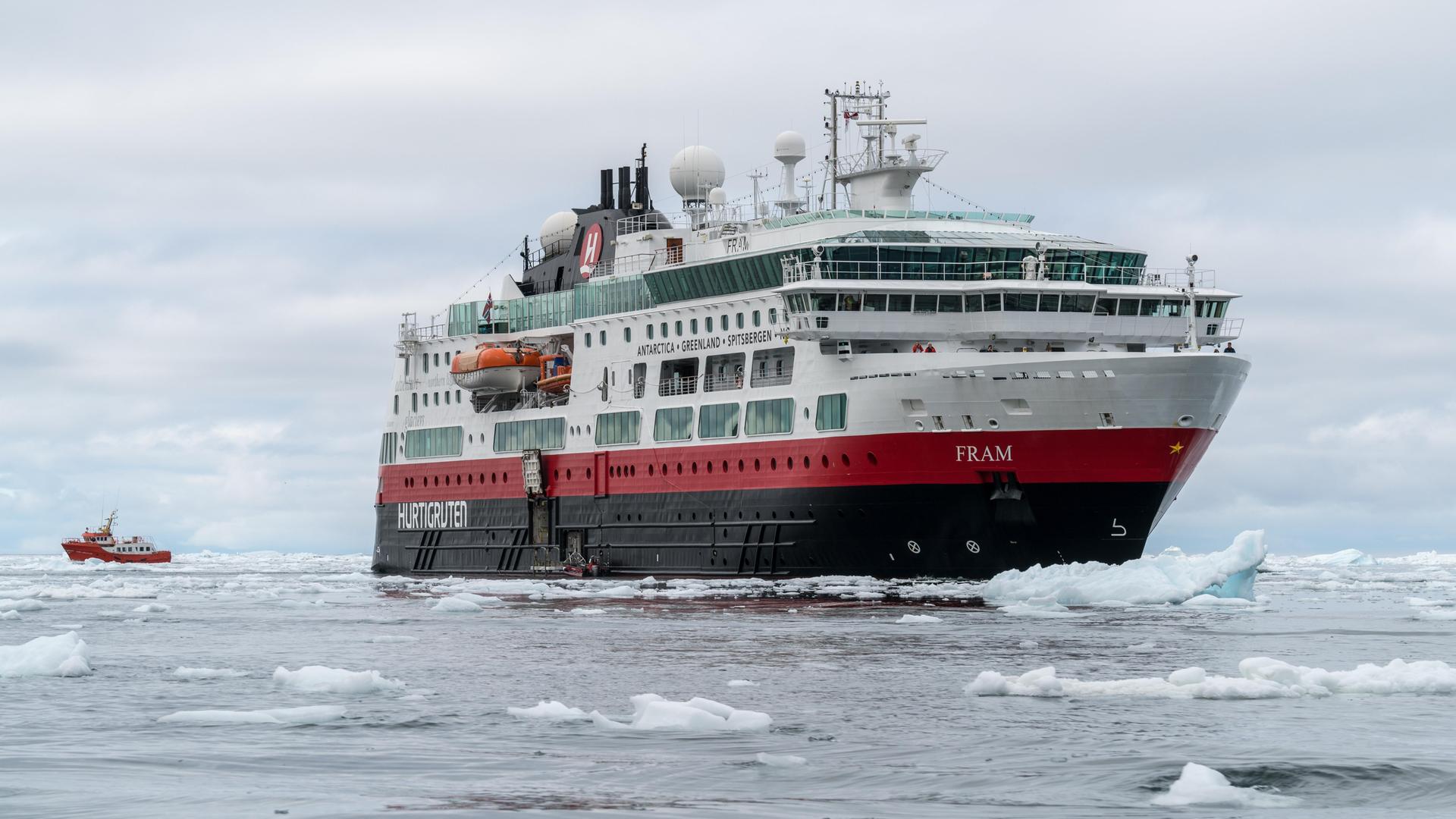 Ein großes Kreuzfahrtschiff fährt durch das Eismeer.