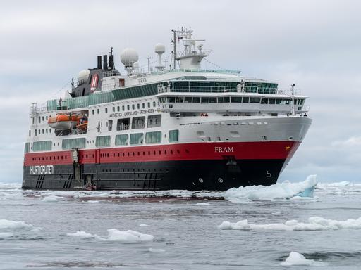 Ein großes Kreuzfahrtschiff fährt durch das Eismeer.