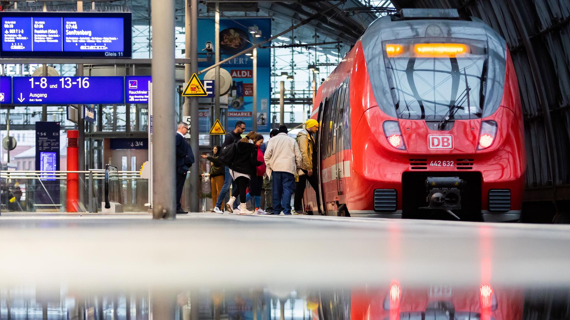 Ein Regionalzug hält am Berliner Hauptbahnhof. (Spiegelung in Pfütze)