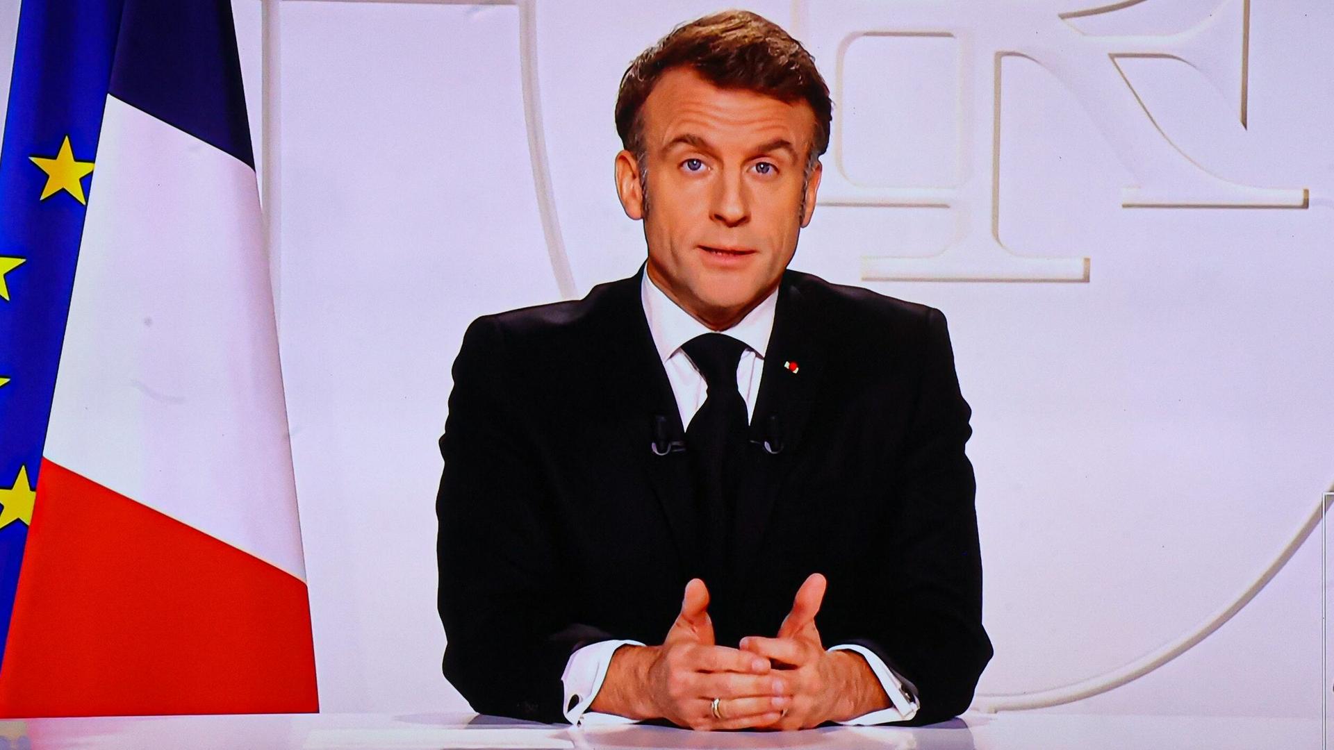 Präsident Macron spricht während einer Fernsehansprache im Elysée-Palast in Paris. Er schaut ernst in die Kamera. 