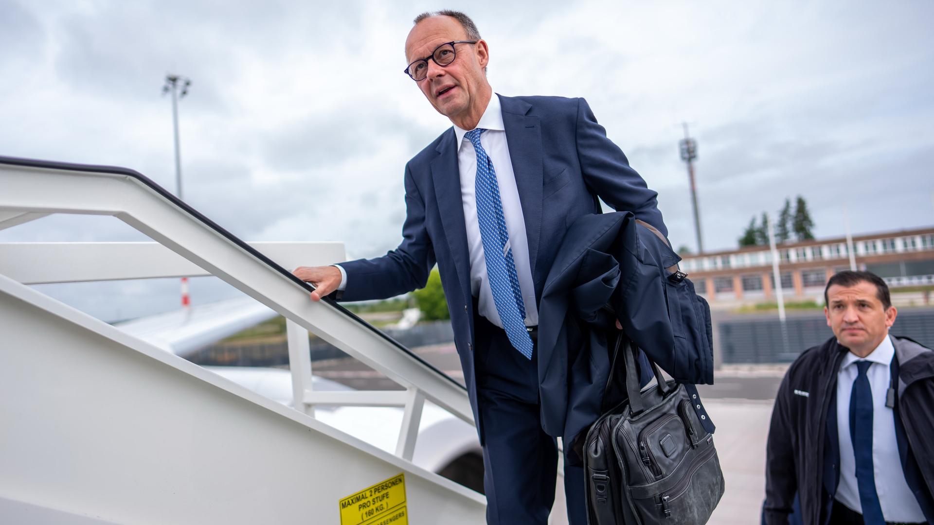 Bundeskanzler Friedrich Merz (CDU) ist von vorne zu sehen, wie er die Treppe zu einem Flugzeug der Flugbereitschaft der Luftwaffe hochsteigt.