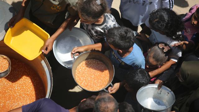Im Gazastreifen wird aus großen Töpfen Essen an Kinder verteilt.