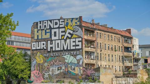 Auf der Fassade des autonomen Hausprojektes Köpi in Berlin ist zu lesen: Hands off our homes! We stay united.