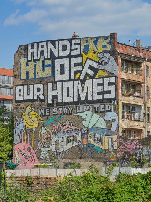 Auf der Fassade des autonomen Hausprojektes Köpi in Berlin ist zu lesen: Hands off our homes! We stay united.