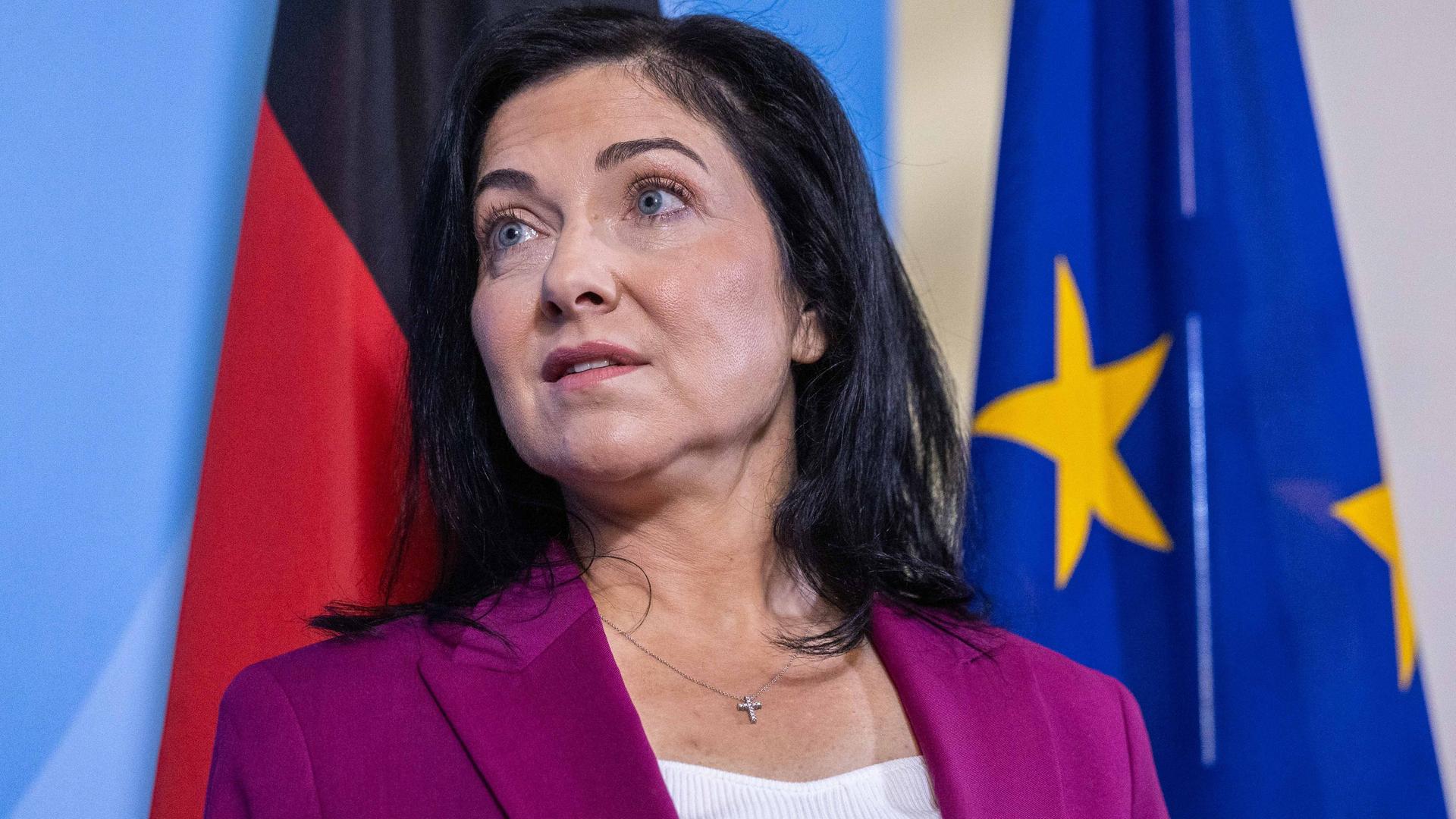 Wirtschafts- und Energieministerin Katherina Reiche trägt ein pinkes Jackett, im Hintergrund sind eine blaue Wand sowie die Deutschland- und die EU-Flagge zu sehen. Wirtschafts- und Energieministerin Katherina Reiche trägt ein pinkes Jackett, im Hintergrund sind eine blaue Wand sowie die Deutschland- und die EU-Flagge zu sehen.