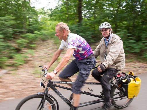 Der Leiter des Tandemprojektes Steffen Kruschwitz (r) fährt am 08.06.2017 in Berlin bei einer Tandemausfahrt mit seinem sehenden Tandempartner auf einem Tandemrad. 