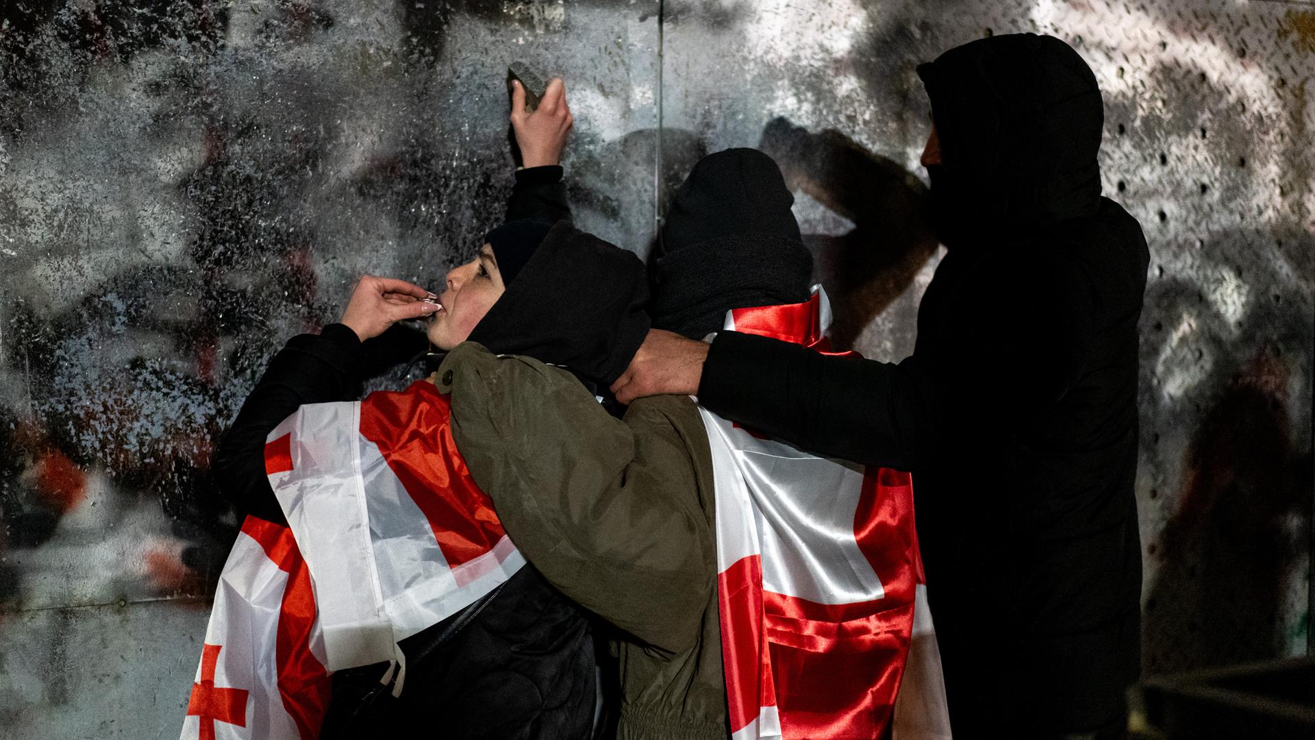 Demonstranten mit georgischen Flaggen schlagen auf die Barrieren ein, die das Parlament während einer Demonstration pro-europäischer Oppositionsaktivisten schützen.