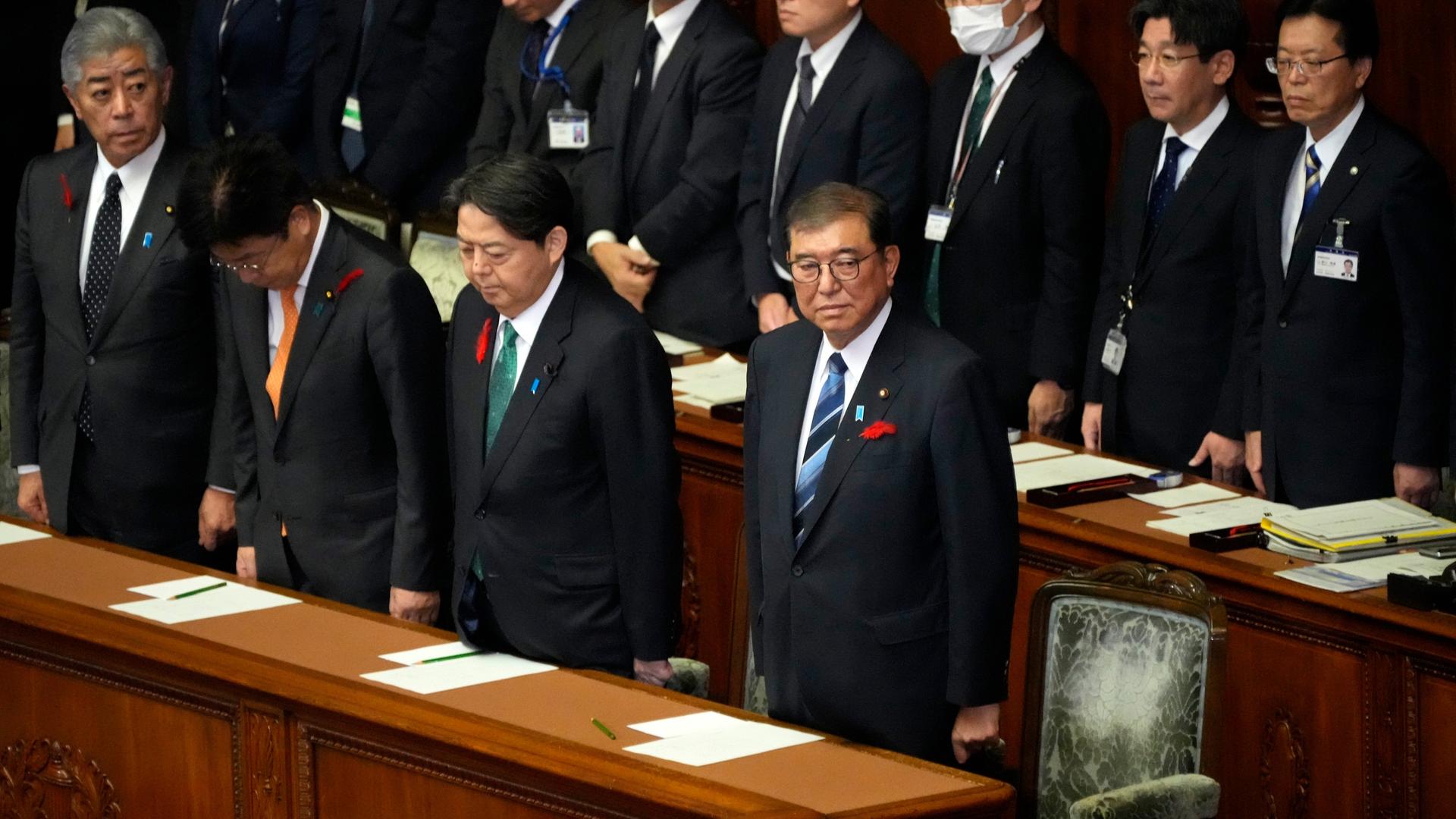 Japans Regierungschef Ishiba steht im Parlament in Tokio. Neben und hinter ihm stehen mehrere Minister.