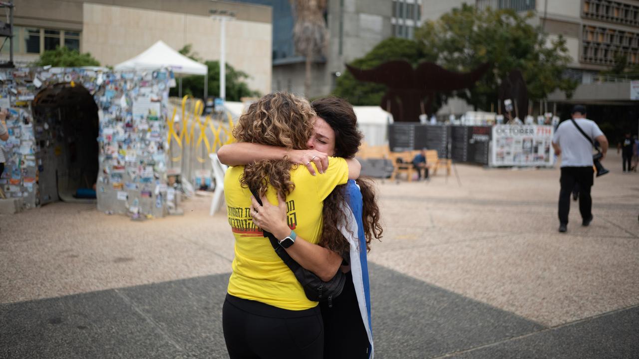 Zwei Frauen umarmen sich auf dem Platz der Geiseln in Tel Aviv. Die eine hat eine israelische Flagge umgebunden, die andere trägt ein gelbes T-Shirt, das die Forderung nach Freilassung der Geiseln symbolisiert. Zwei Frauen umarmen sich auf dem Platz der Geiseln in Tel Aviv. Die eine hat eine israelische Flagge umgebunden, die andere trägt ein gelbes T-Shirt, das die Forderung nach Freilassung der Geiseln symbolisiert.