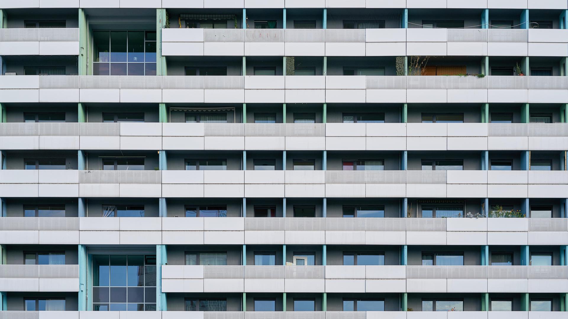 Symetrische Frontalansicht der Fassade eines sanierten DDR-Plattenbaus. 