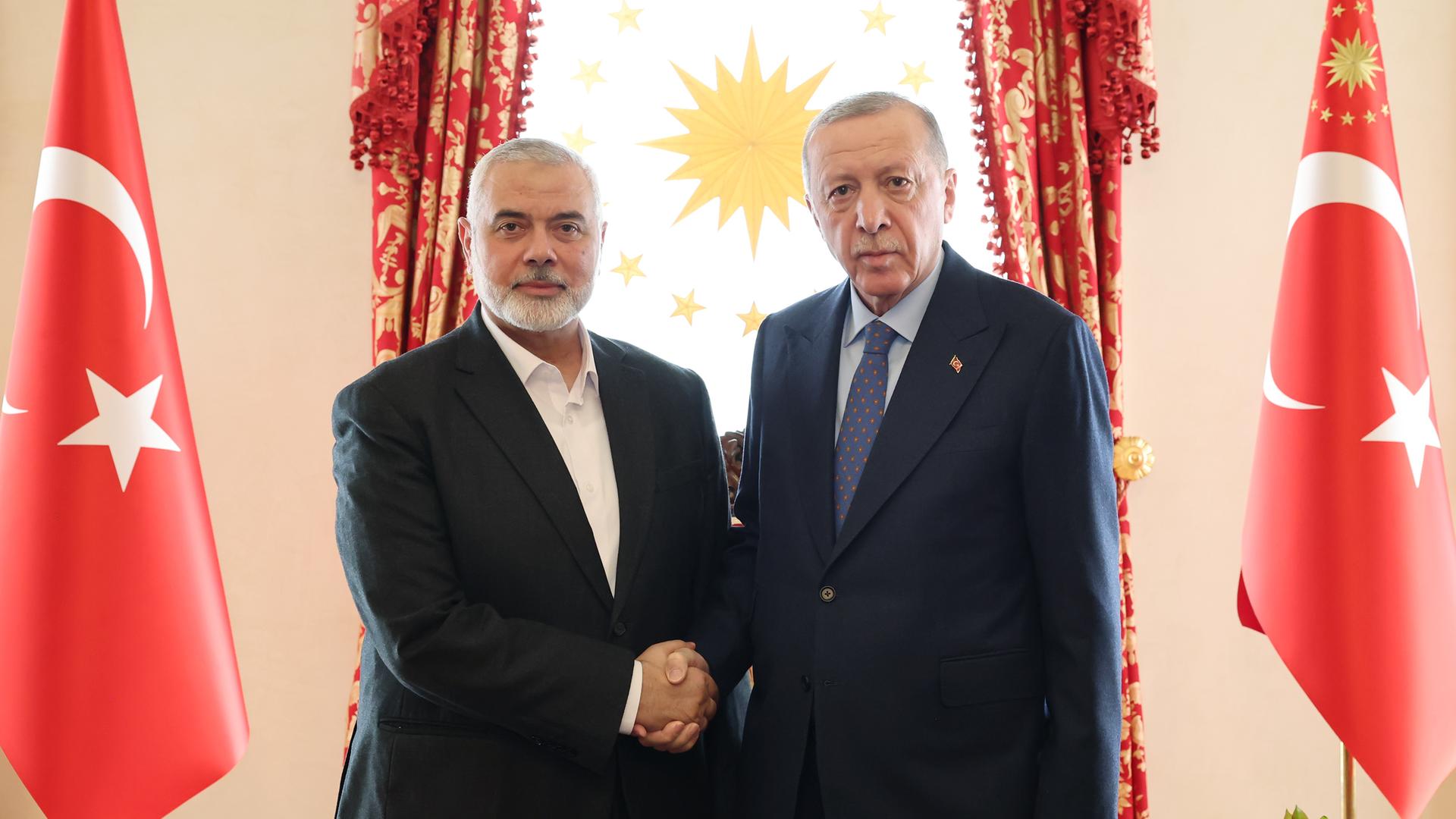 Der türkische Präsident Recep Tayyip Erdogan und Hamas-Führer Ismail Haniyeh in Istanbul inmitten türkischer Fahnen.  