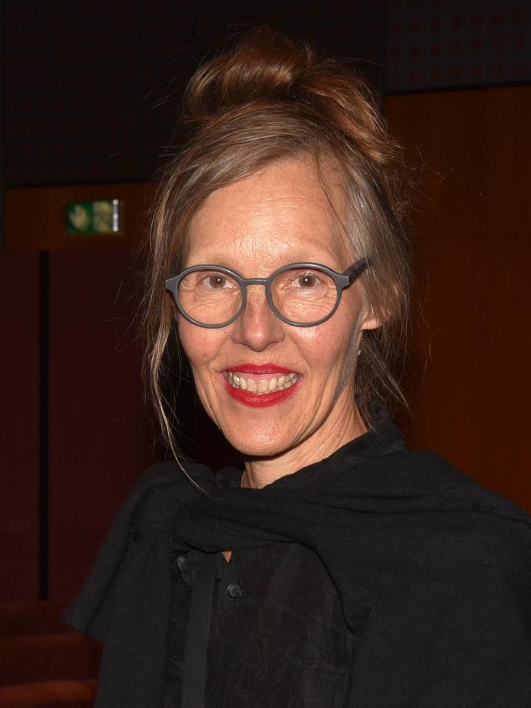 Porträt von Donata Wenders vor dunklem Hintergrund. Sie lacht in die Kamera.