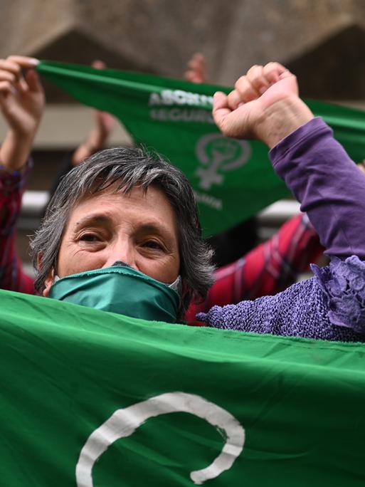 Frauen mit grünen Mund-Nasen-Bedeckungen schwenken grüne Tücher während einer Kundgebung vor der Bischofskonferenz in Bolivien 