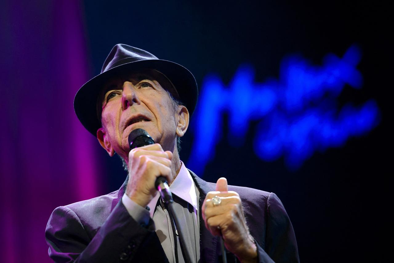 Songwriter Leonard Cohen mit einem Hut beim Bühnenauftritt.