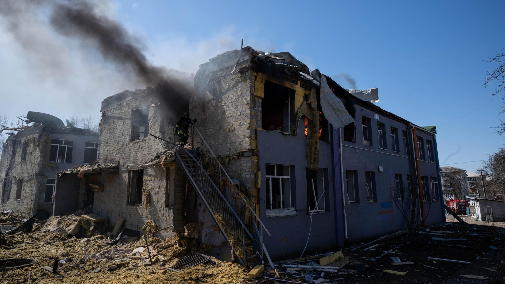 Ein Schulgebäude ist nach einem Luftangriff in Kramatorsk in der ukrainischen Region Donezk stark beschädigt worden. Feuerwehrleute löschen den Brand, während über dem Gebäude noch Rauch aufsteigt.