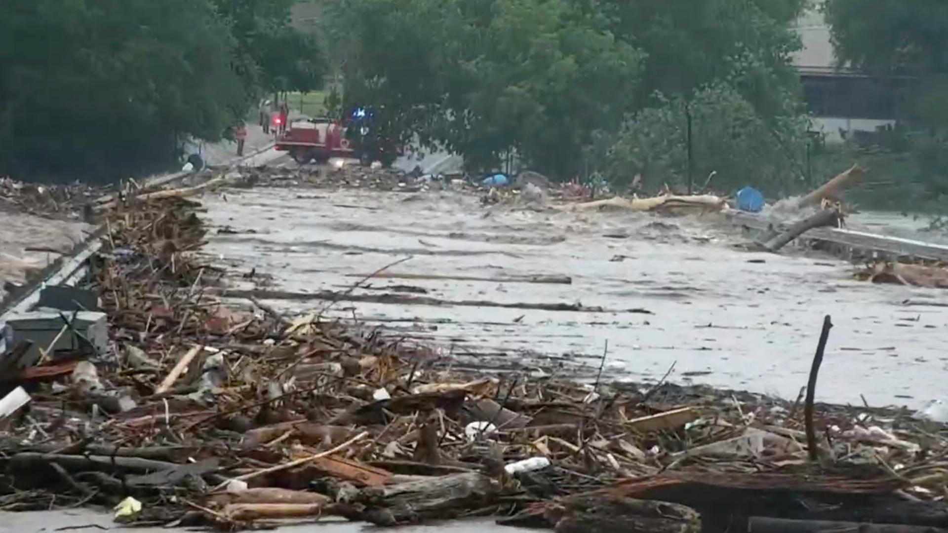 Ein Fluss ist über die Ufer getreten und hat eine Straße überflutet. Ein Fluss ist über die Ufer getreten und hat eine Straße überflutet.