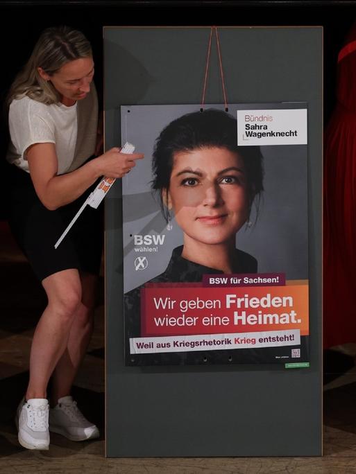 Mitglieder des Landesverbandes Sachsen hängen die Plakate für die Präsentation der Kampagne für die Landtagswahl des Bündnis Sahra Wagenknecht - Vernunft und Gerechtigkeit (BSW) auf.