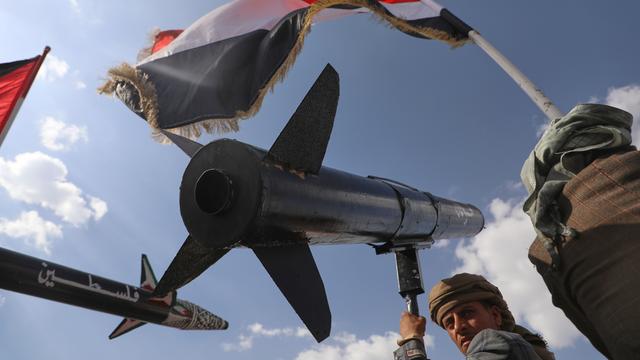 Ein Huthi-Anhänger skandiert Slogans, während er eine Raketennachbildung trägt.