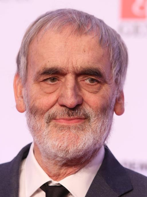 Wir sehen den Komponisten Helmut Lachenmann. Er blickt lächelnd in die Kamera. 