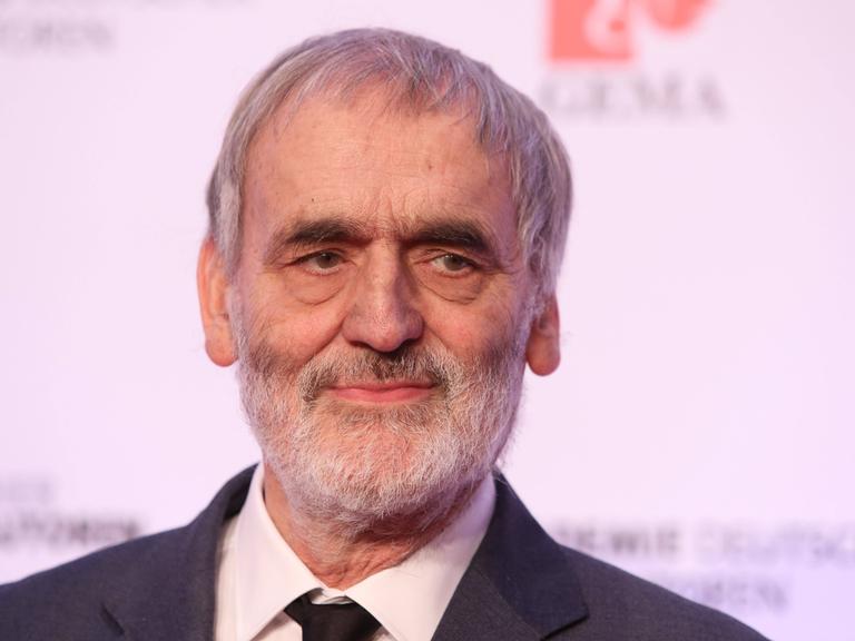 Wir sehen den Komponisten Helmut Lachenmann. Er blickt lächelnd in die Kamera. 