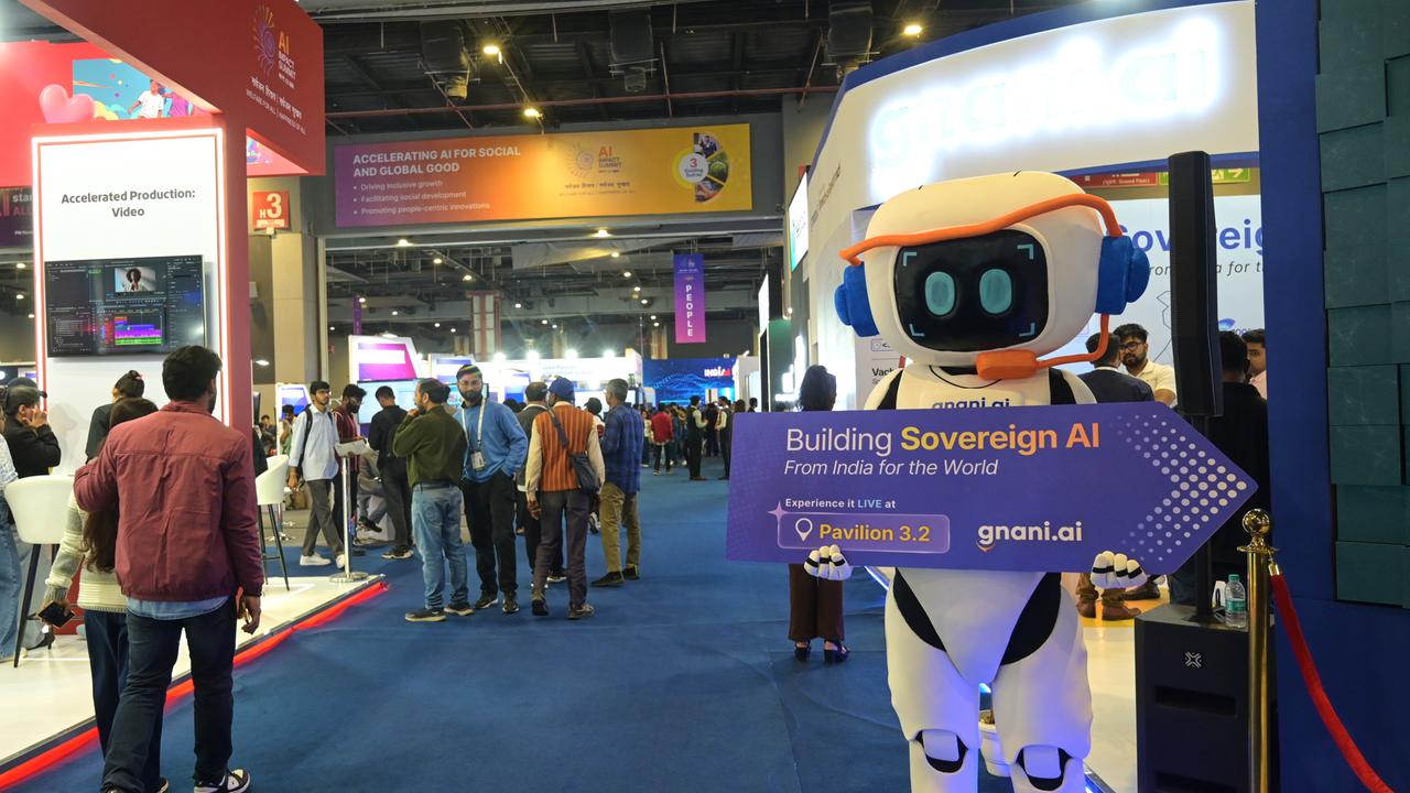 Eine Roboterfigur hält ein Schild mit der Aufschrift "Building Sovereign AI" (Entwicklung einer souveränen KI) beim KI-Gipfel im indischen Neu Delhi.