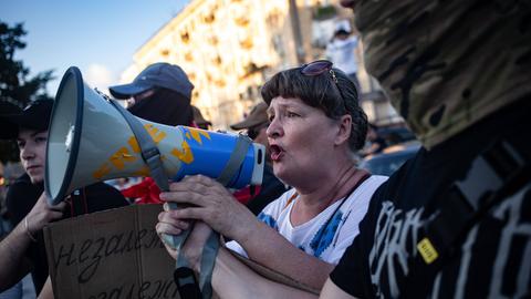 Eine Frau schreit in ein Megaphon auf einer Demonstration in der Ukraine.