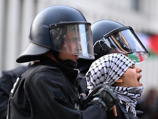Eine der propalästinensischen Besetzerinnen des Instituts für Sozialwissenschaften der Berliner Humboldt-Universität (HU) wird am 23. Mai 2024 von zwei Polizisten aus dem Gebäude herausgeführt. 