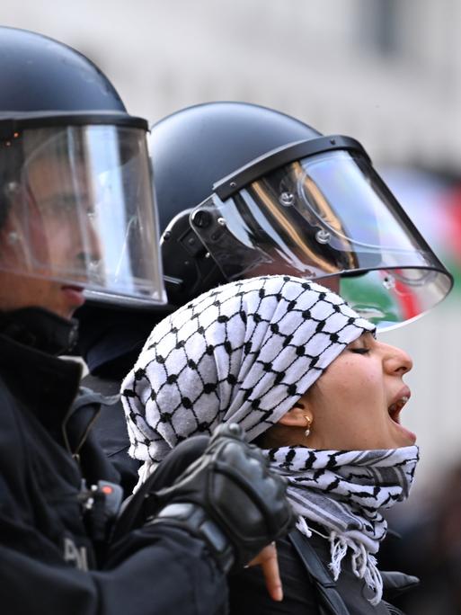 Eine der propalästinensischen Besetzerinnen des Instituts für Sozialwissenschaften der Berliner Humboldt-Universität (HU) wird am 23. Mai 2024 von zwei Polizisten aus dem Gebäude herausgeführt. 