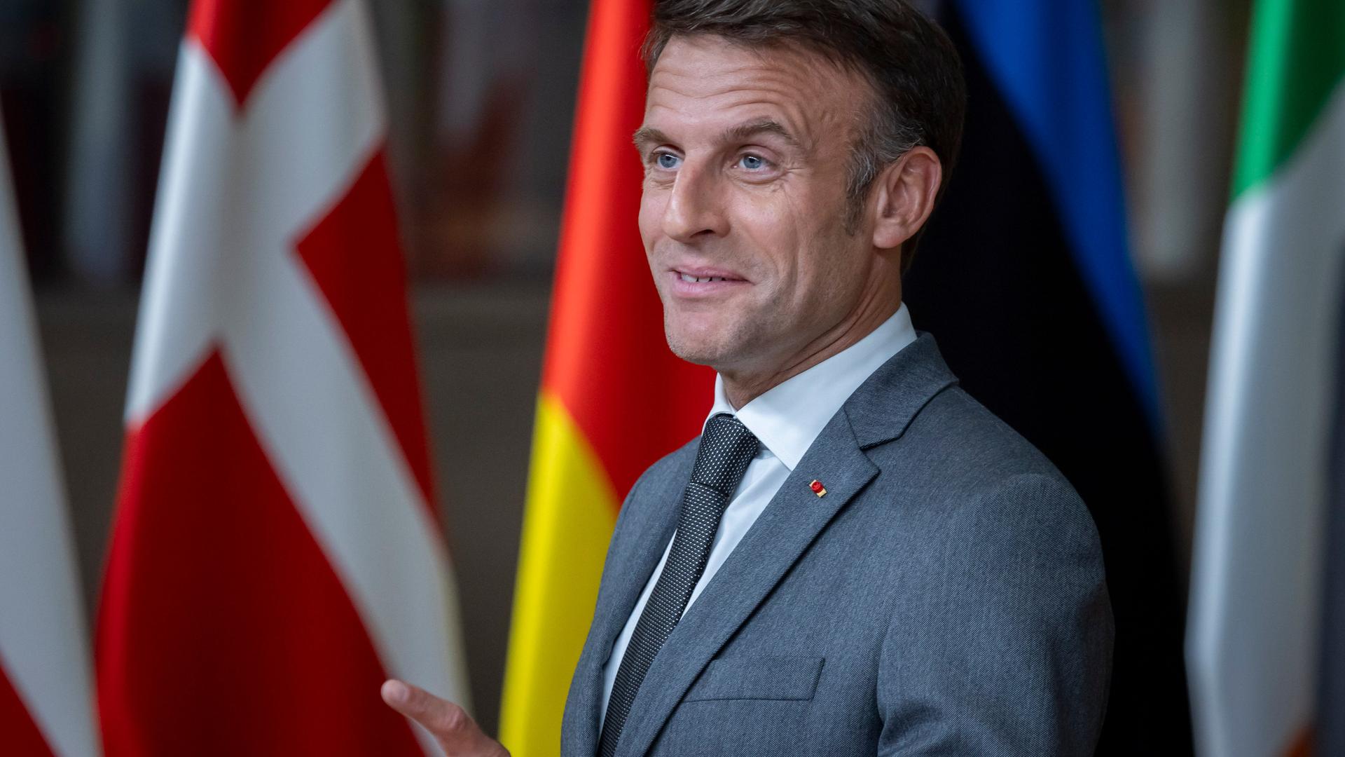 Emmanuel Macron steht hinter einem Pult und zieht eine Grimasse.