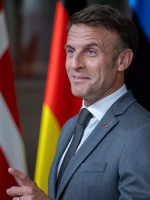 Emmanuel Macron steht hinter einem Pult und zieht eine Grimasse.