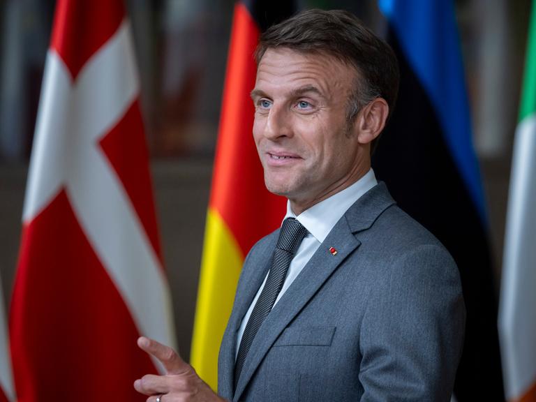 Emmanuel Macron steht hinter einem Pult und zieht eine Grimasse.