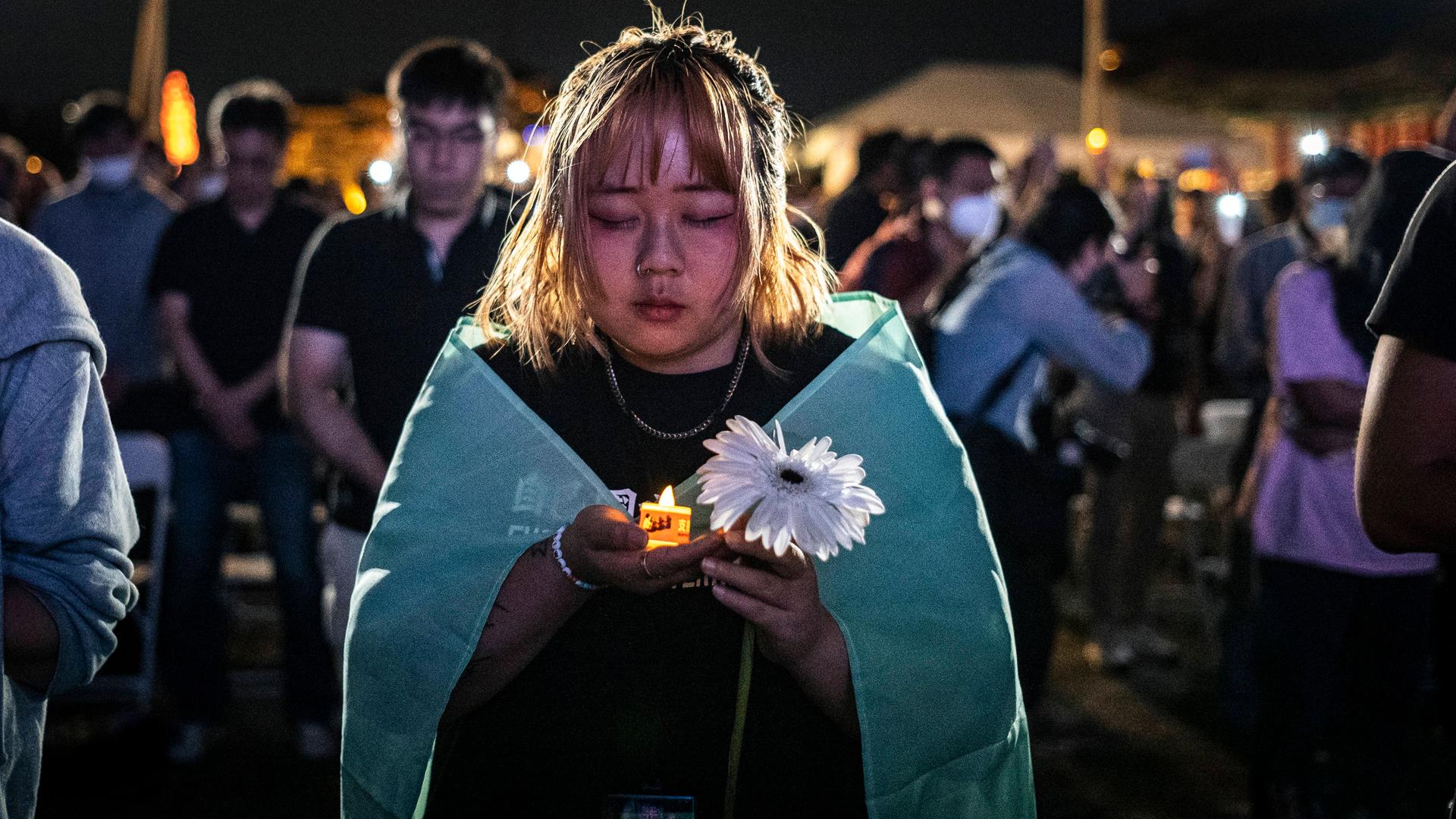 Menschen halten elektrische Kerzen, während sie an einer Mahnwache zum 35. Jahrestag des Tiananmen-Massakers von 1989 teilnehmen.