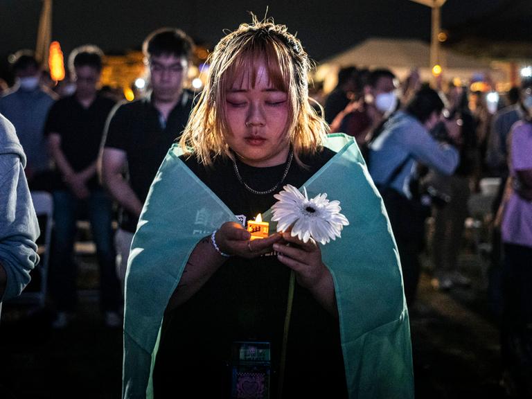 Menschen halten elektrische Kerzen, während sie an einer Mahnwache zum 35. Jahrestag des Tiananmen-Massakers von 1989 teilnehmen.