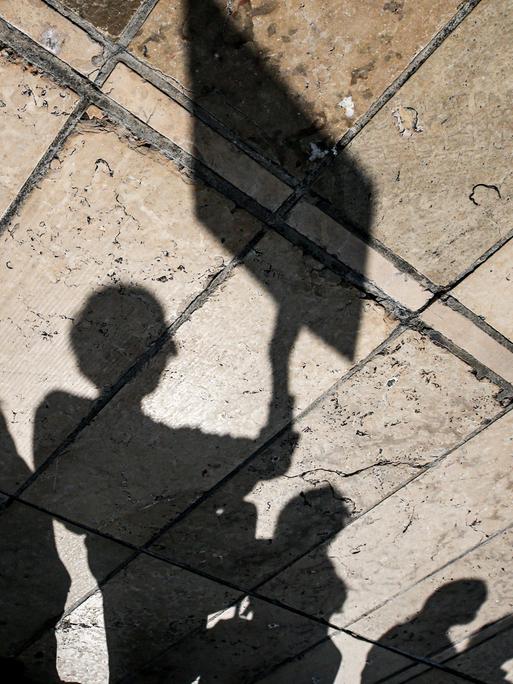 Schatten von Protestierenden mit Bannern.