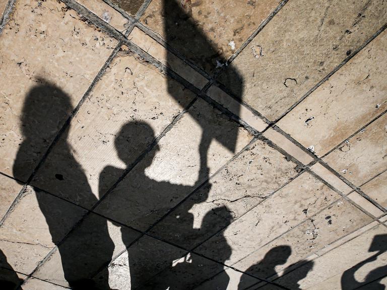 Schatten von Protestierenden mit Bannern.