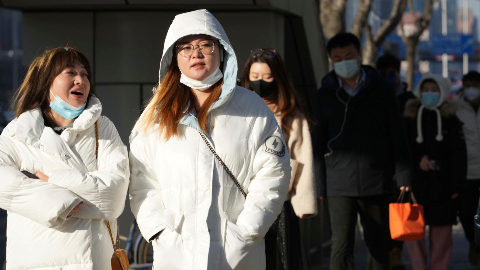 Menschen in Peking laufen ohne Maske durch die Straßen.