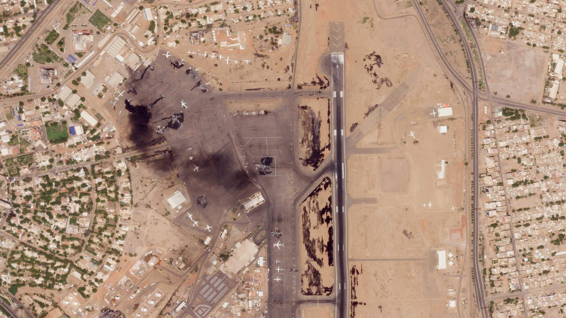 Khartoum: Dieses Satellitenfoto von Planet Labs PBC zeigt beschädigte Flugzeuge, darunter ein brennendes, auf dem internationalen Flughafen von Khartum.