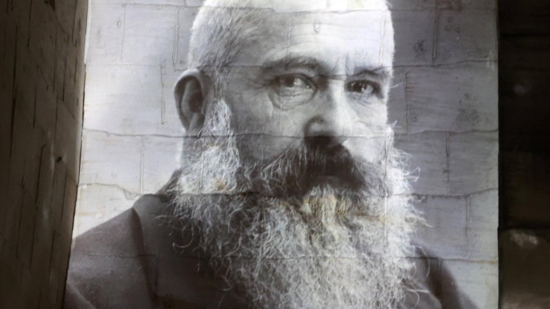 Eine Fotografie des französischen Malers Claude Monet an eine weiße Wand projeziert